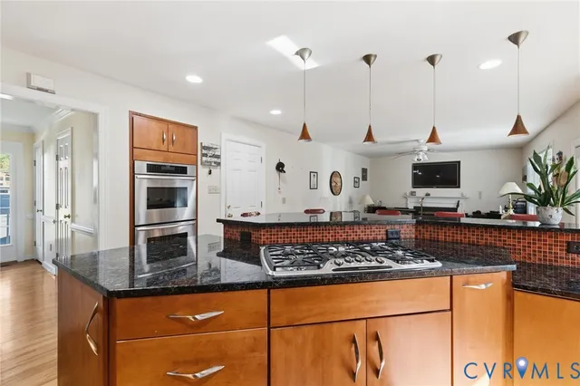 a kitchen with stainless steel appliances granite countertop a stove a sink and a microwave