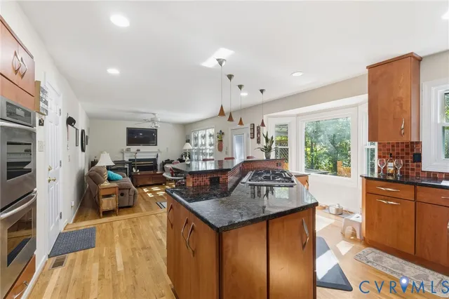 a kitchen with stainless steel appliances granite countertop a sink a stove and refrigerator