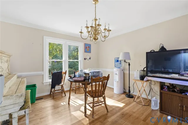 a view of a dining room with furniture a chandelier and wooden floor