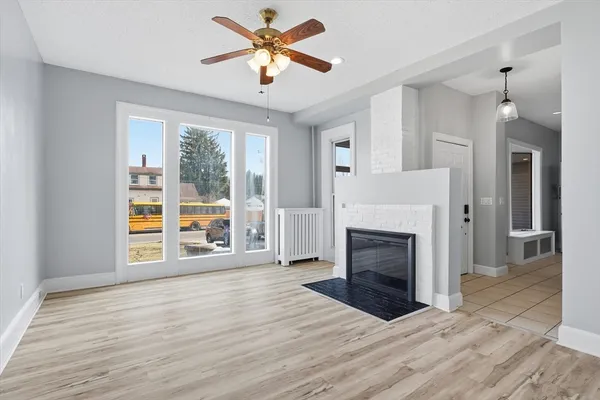 a hallway with wooden floor a fireplace and entryway
