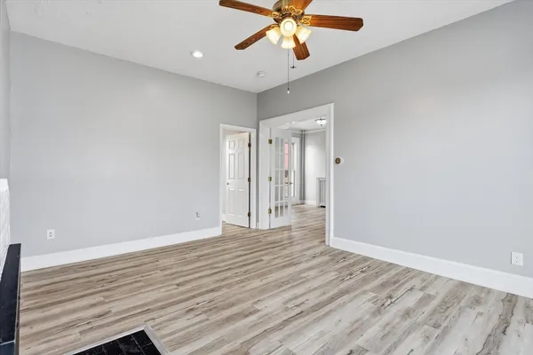 a view of an empty room with wooden floor