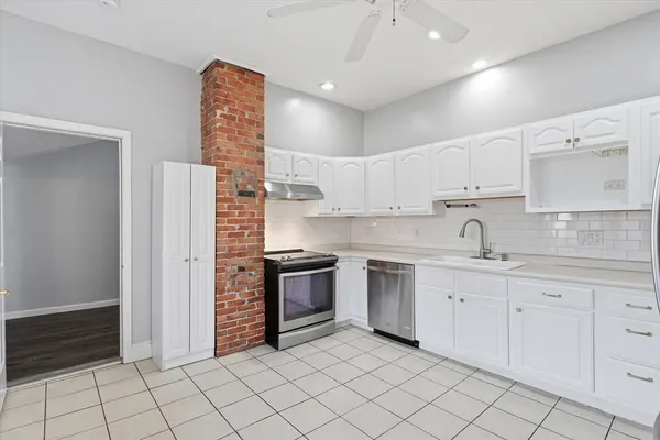 a kitchen with white cabinets stainless steel appliances and sink