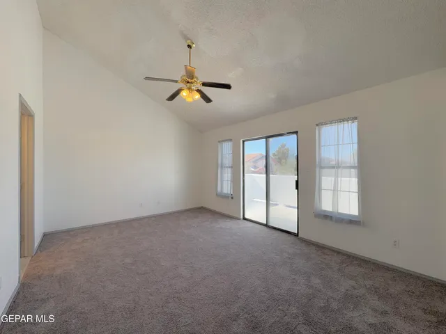 an empty room with windows and fan