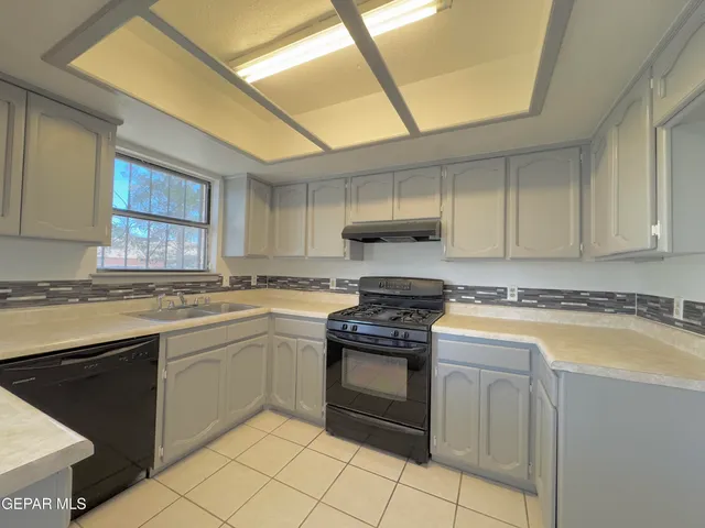 a kitchen with a stove sink and cabinets