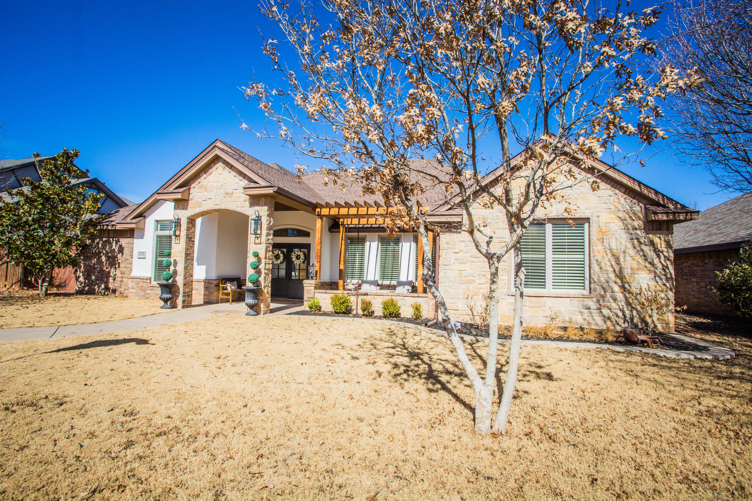 6018 87th Street Lubbock, TX 79424 - Photo 1 of 98 a front view of a house with a large tree in front of it