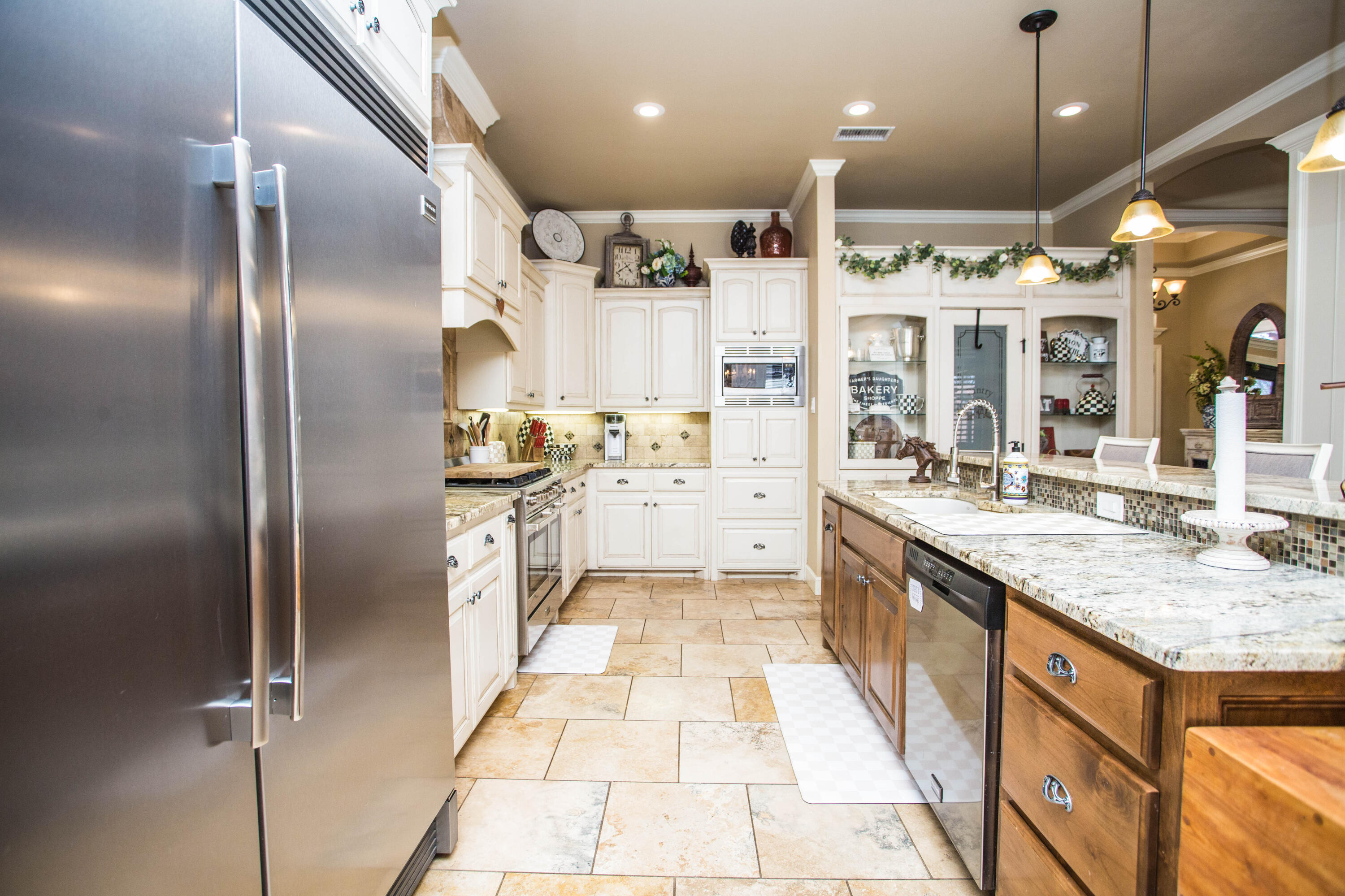 6018 87th Street Lubbock, TX 79424 - Photo 19 of 98 a large kitchen with stainless steel appliances kitchen island granite countertop a refrigerator and a sink