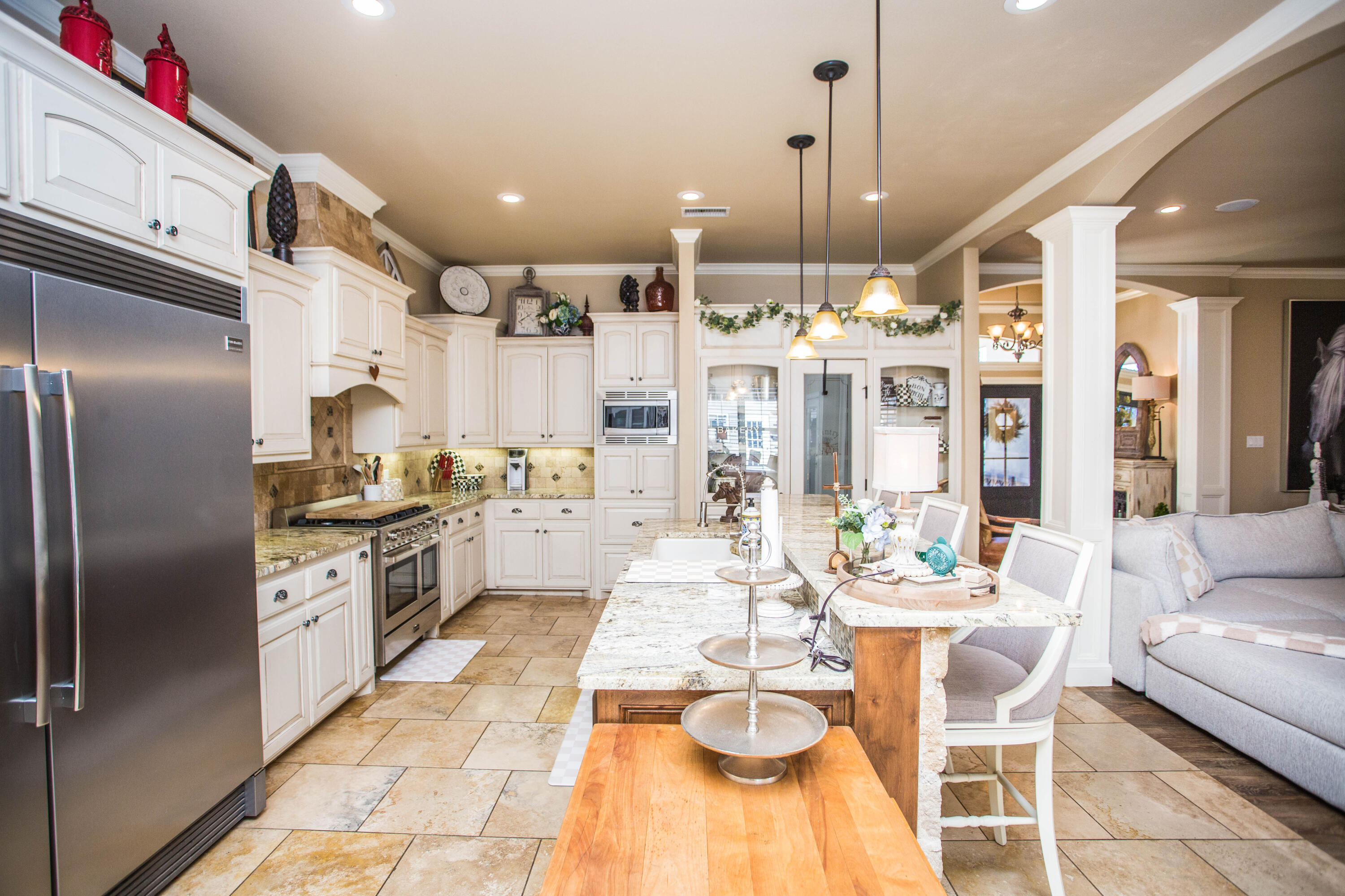 6018 87th Street Lubbock, TX 79424 - Photo 20 of 98 a kitchen with stainless steel appliances kitchen island granite countertop a refrigerator a stove a kitchen island a dining table and chairs