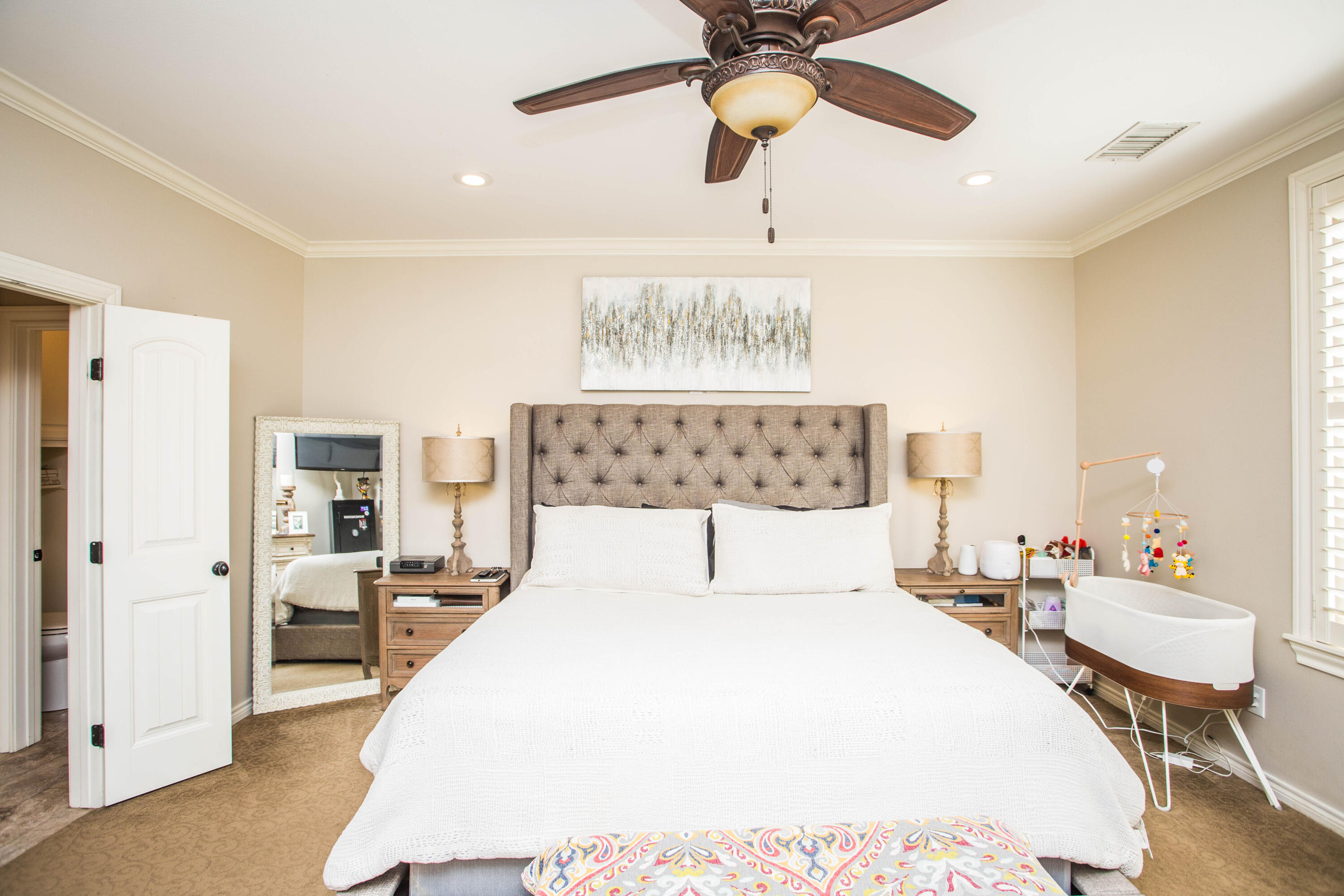 6018 87th Street Lubbock, TX 79424 - Photo 30 of 98 a bedroom with a bed and a chandelier