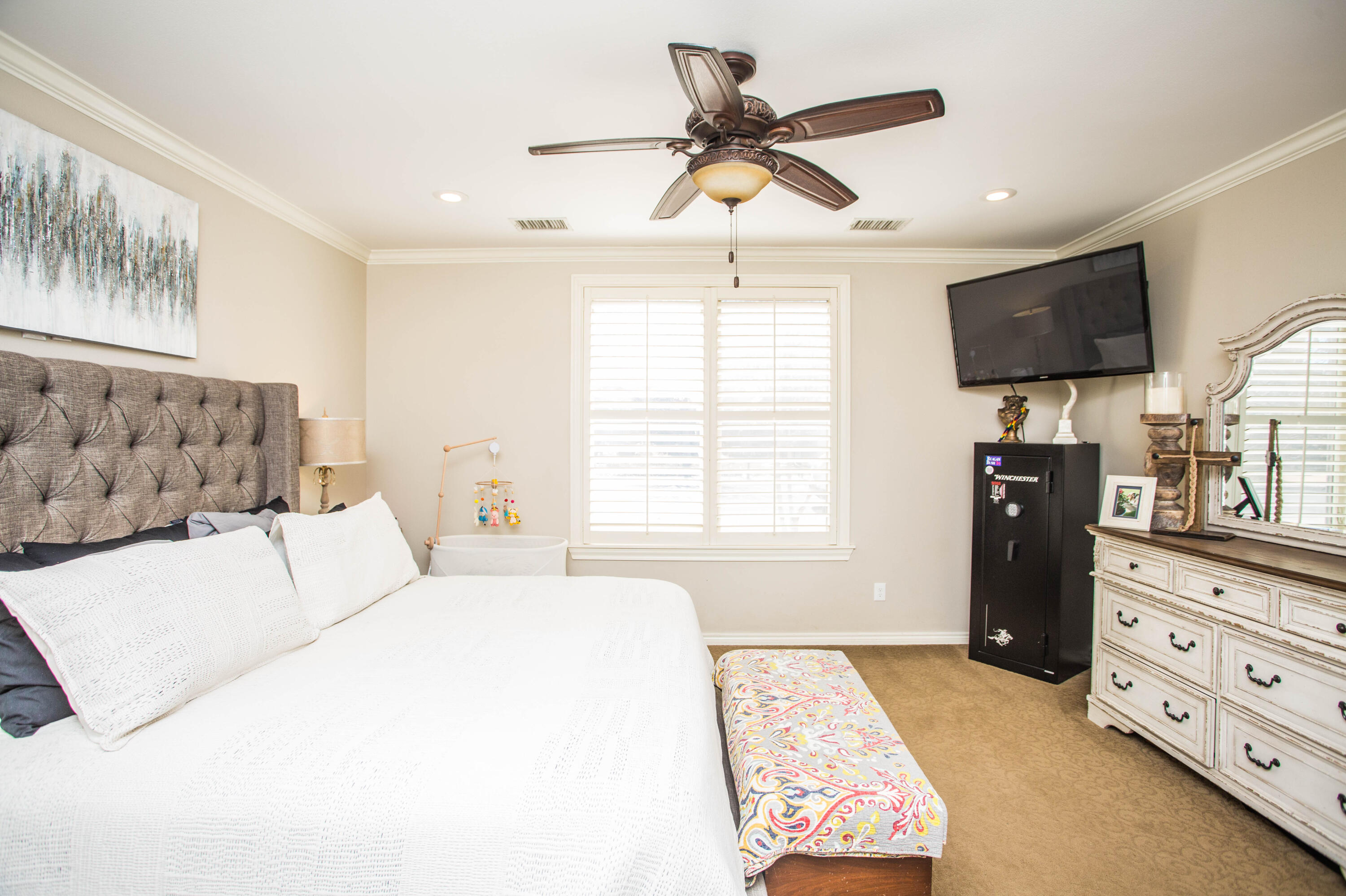 6018 87th Street Lubbock, TX 79424 - Photo 31 of 98 a bedroom with a bed a flat screen tv and a window
