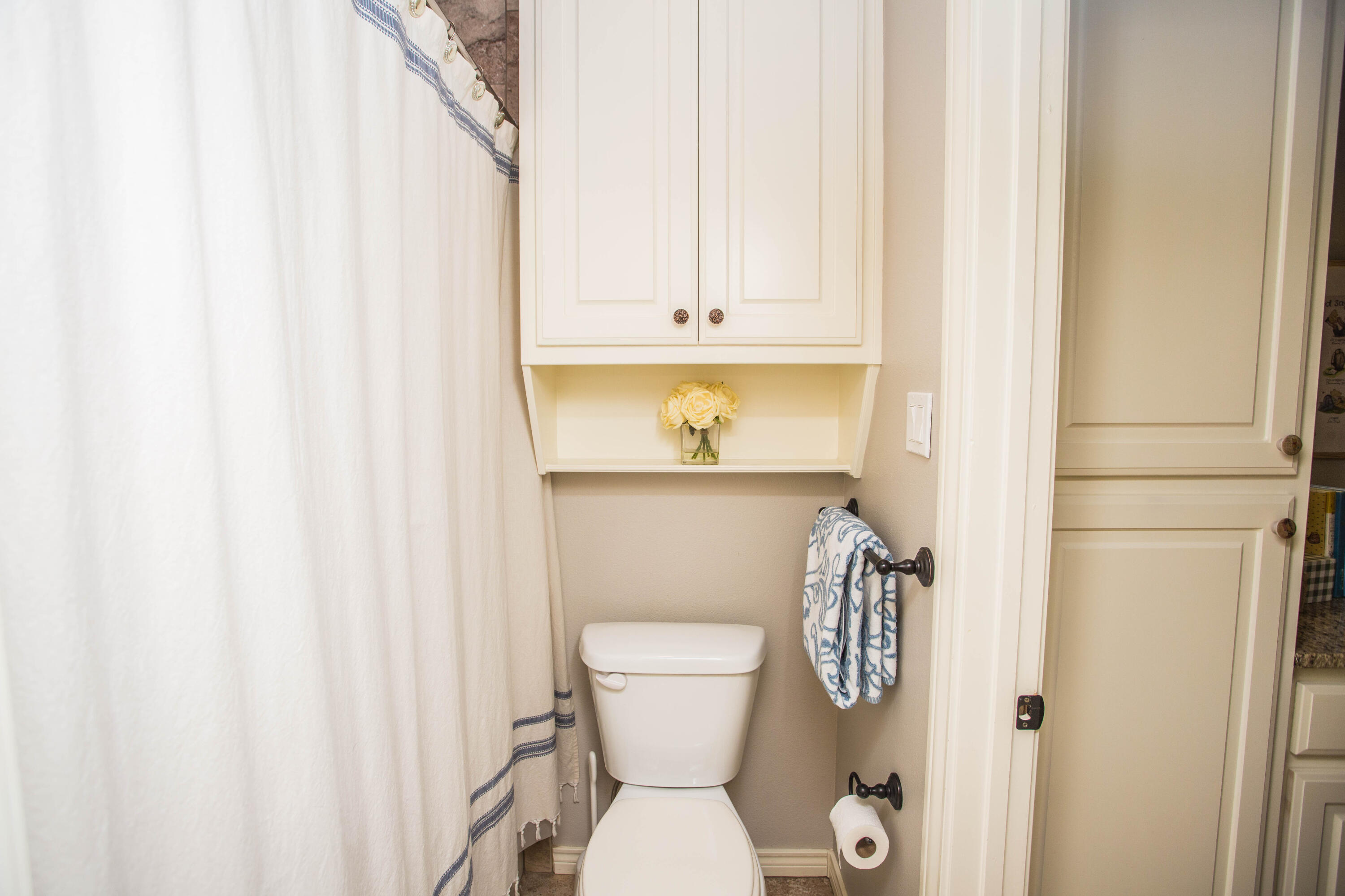6018 87th Street Lubbock, TX 79424 - Photo 52 of 98 a bathroom with a toilet and a shower curtain