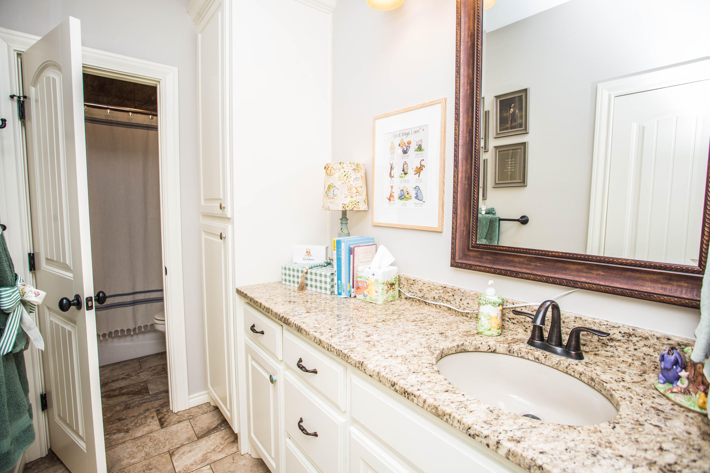 6018 87th Street Lubbock, TX 79424 - Photo 54 of 98 a bathroom with a granite countertop sink and a mirror