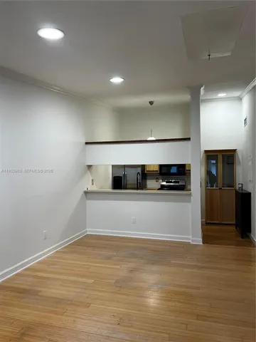 a view of an empty room with wooden floor