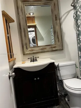 a bathroom with a sink toilet and mirror