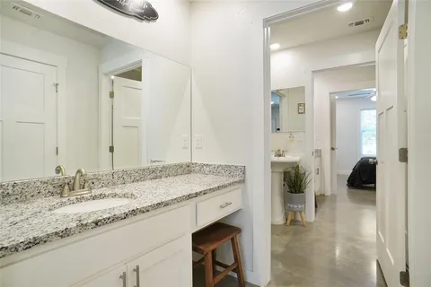 a spacious bathroom with a granite countertop sink and a mirror