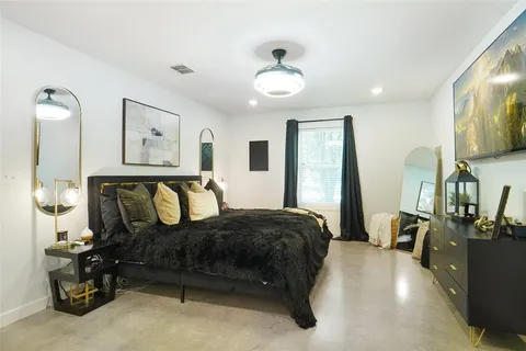 a bedroom with a bed mirror and window