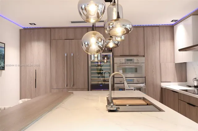 a kitchen with kitchen island granite countertop a refrigerator and a stove