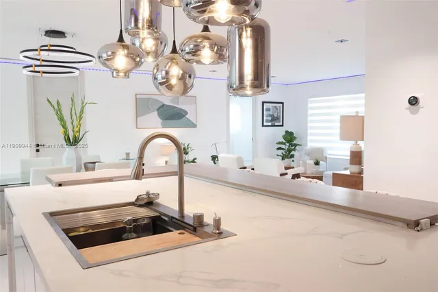 a kitchen with kitchen island granite countertop a stove a sink and a dining table with wooden floor