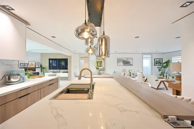 a large kitchen with a table chairs a stove and a chandelier