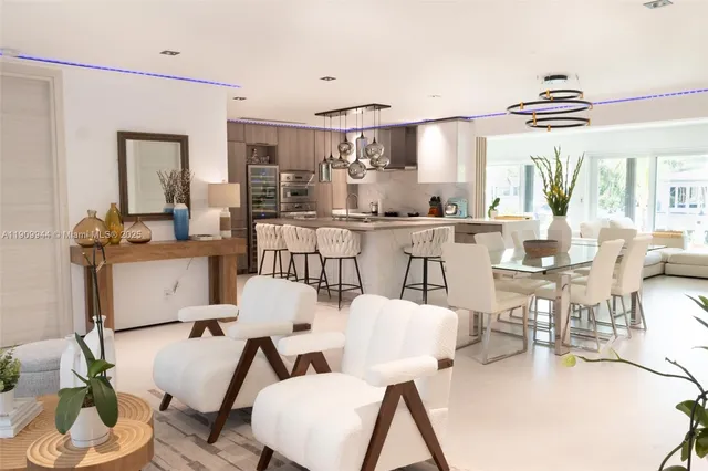 a view of a dining room with furniture a kitchen and chandelier