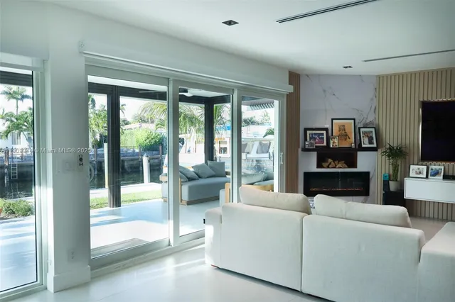 a living room with furniture a flat screen tv and a floor to ceiling window