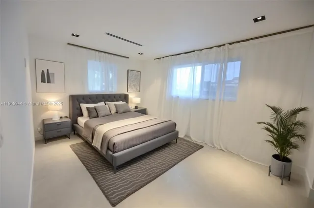 a bedroom with a large bed and a potted plant