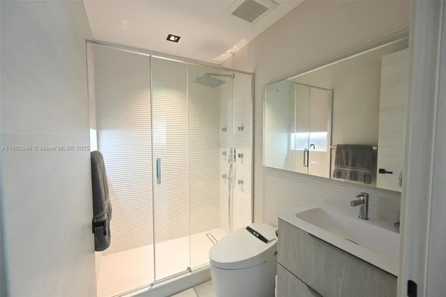 a bathroom with a double vanity sink toilet and shower