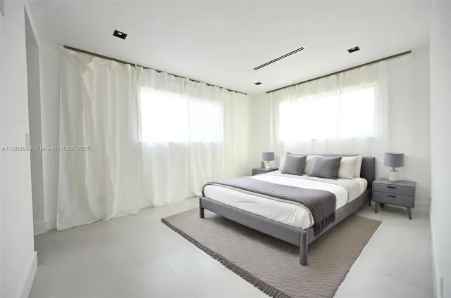 a spacious bedroom with a bed and a window