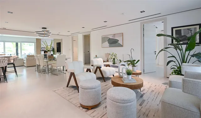 a living room with furniture a chandelier and a dining table