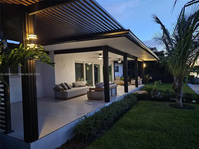a view of a house with backyard and sitting area