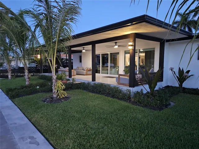 a view of a house with backyard sitting area and garden