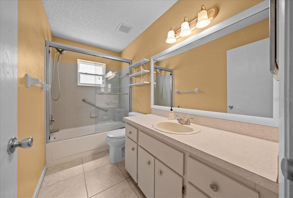 8720 Southwest 90th Street, Unit A Ocala, FL 34481 - Photo 30 of 71 a bathroom with a granite countertop sink a toilet and shower