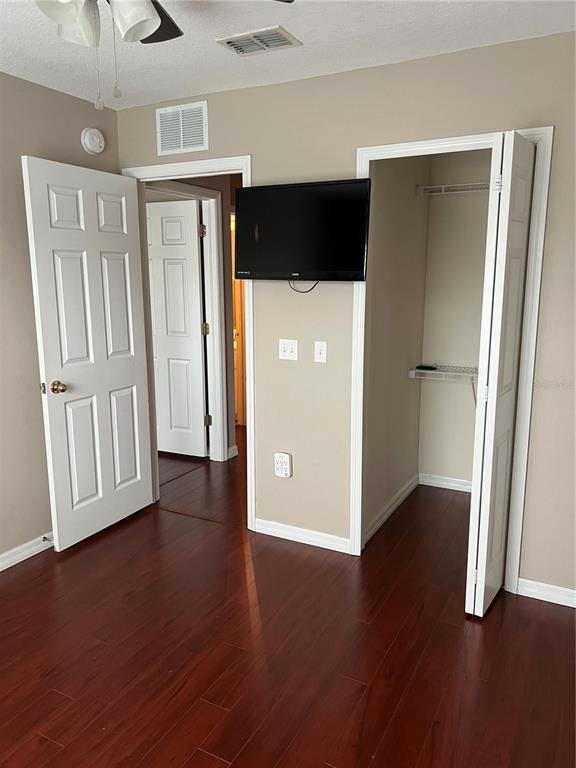 3803 Herlong Street New Port Richey, FL 34655 - Photo 17 of 22 an empty room with wooden floor and a ceiling fan