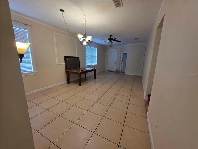 a view of a livingroom with a fireplace a chandelier and wooden floor