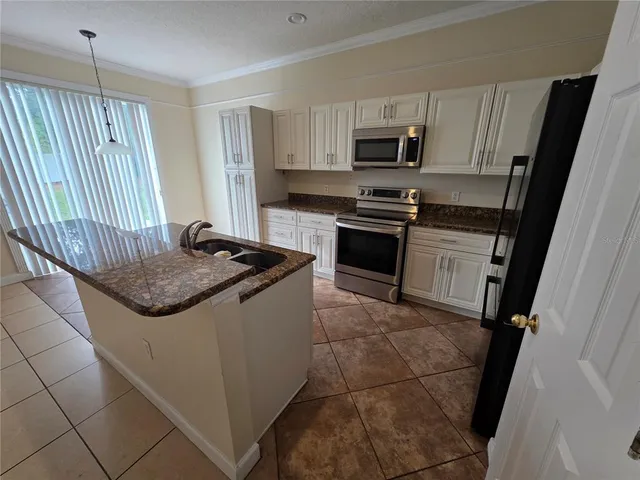 a kitchen with granite countertop stainless steel appliances and a sink