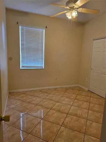 a view of an empty room with a chandelier fan