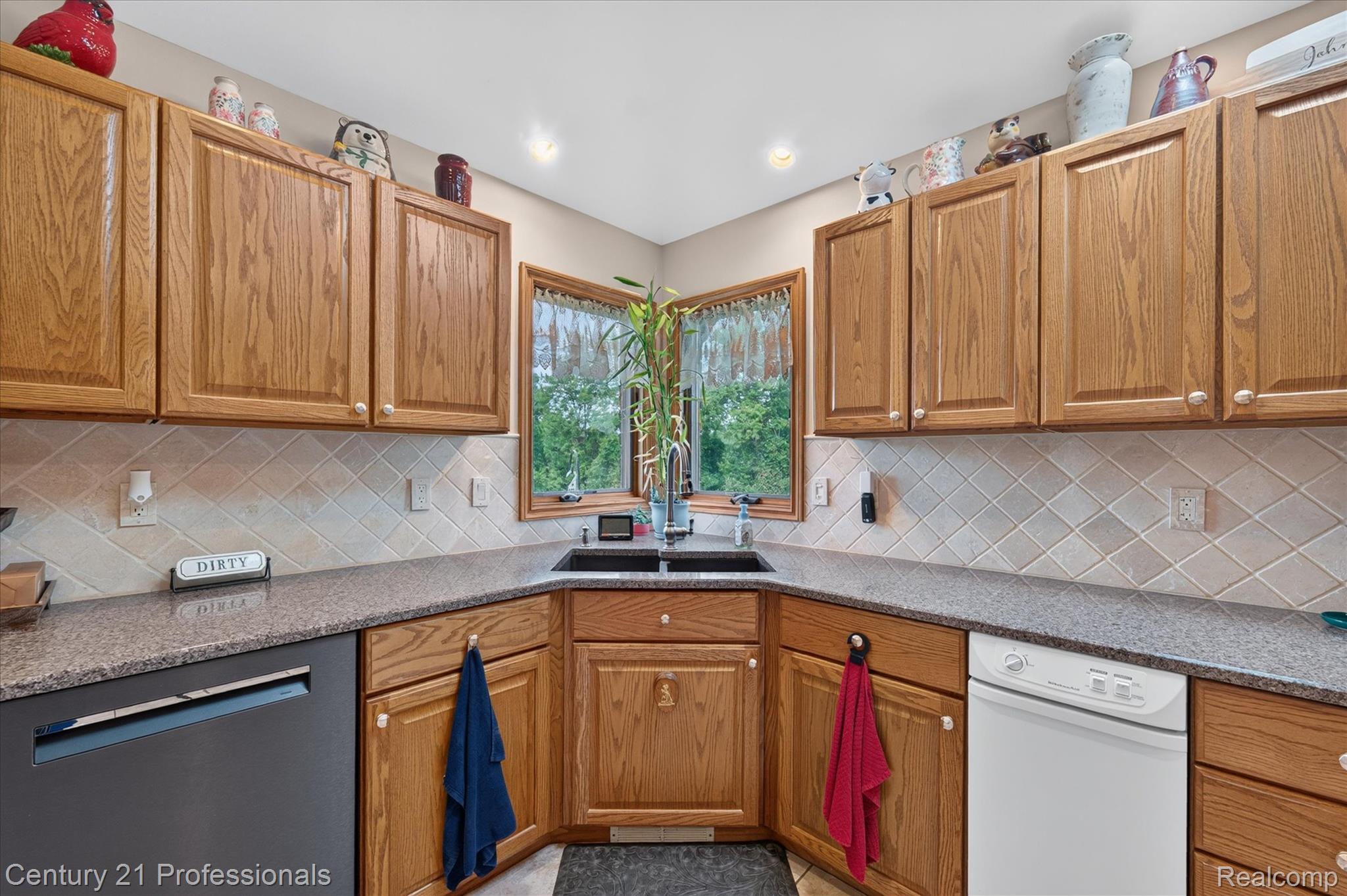 5675 36 Mile Road Romeo, MI 48065 - Photo 24 of 54 Kitchen featuring light wood cabinetry, quartz finish countertops, a corner sink with double windows, a diagonal tile backsplash, and recessed lighting