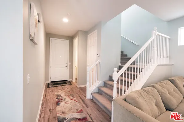 a living room with wooden floor and stairs