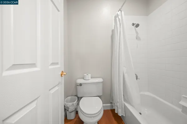 a white toilet sitting next to a bath tub
