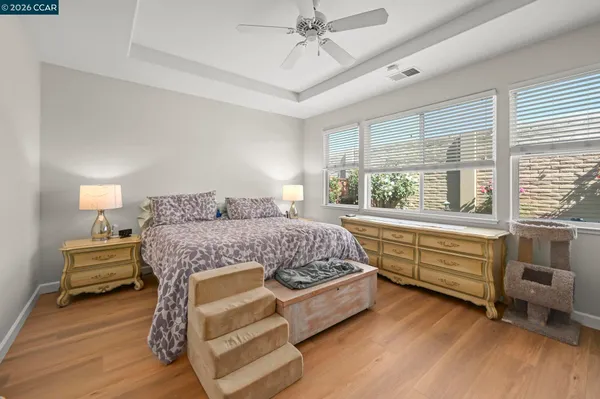 a bedroom with a bed and large windows