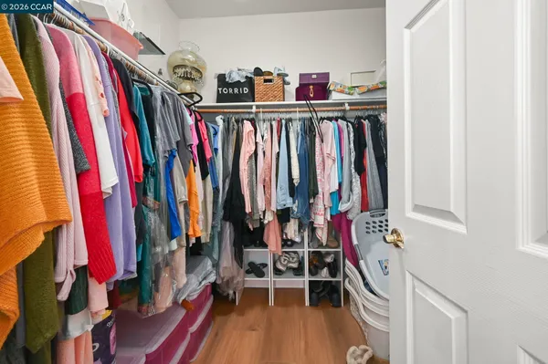 a view of walk in closet with clothes