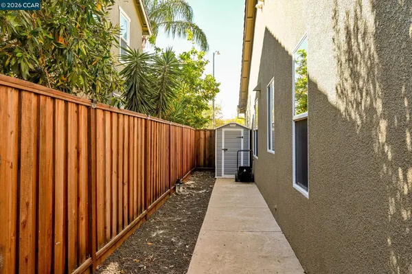 a view of a wooden fence with a small yard