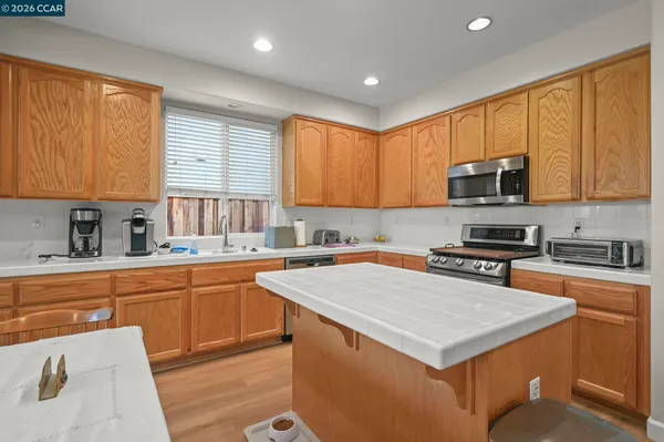 a kitchen with stainless steel appliances a stove a sink a microwave and wooden cabinets