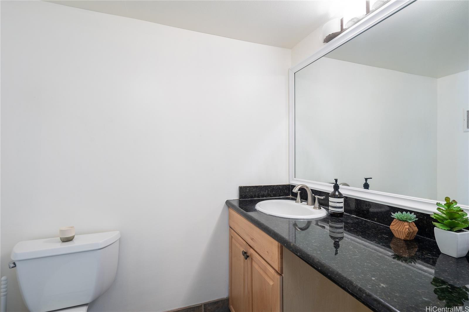 1615 Wilder Avenue, Unit 507 Honolulu, HI 96822 - Photo 13 of 20 a bathroom with a granite countertop sink and a toilet
