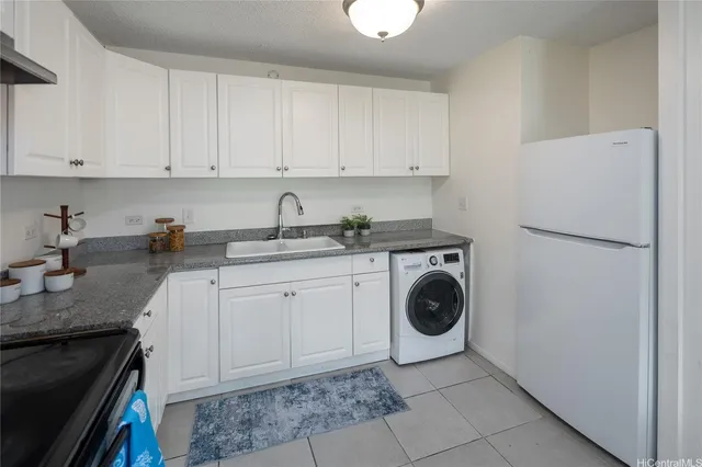 a utility room with cabinets washer and dryer