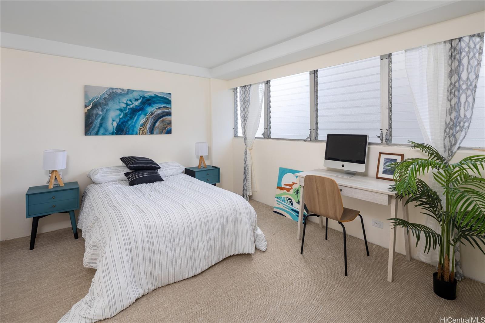 1615 Wilder Avenue, Unit 507 Honolulu, HI 96822 - Photo 7 of 20 a bedroom with a bed a computer on the desk and a potted plant