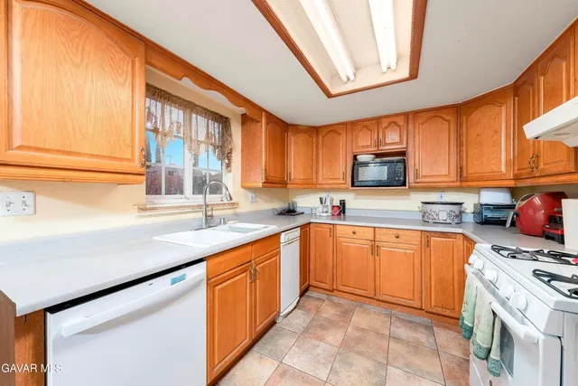 a kitchen with stainless steel appliances granite countertop a sink a stove and cabinets