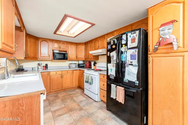 a kitchen with stainless steel appliances granite countertop a refrigerator and a sink