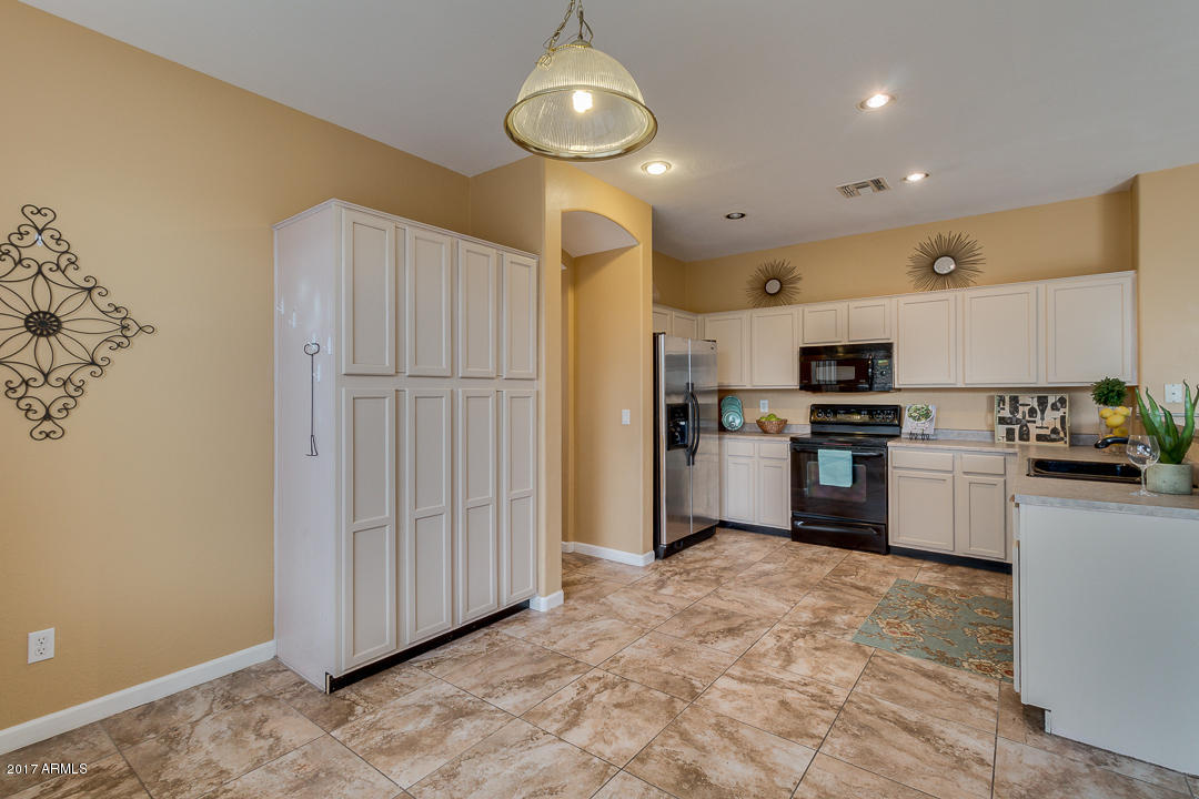 2803 West Lamar Road Phoenix, AZ 85017 - Photo 15 of 47 a kitchen with white cabinets and stainless steel appliances