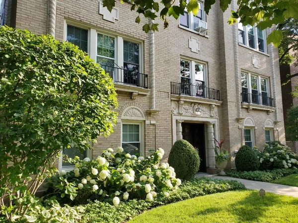 a front view of a residential houses with yard and green space