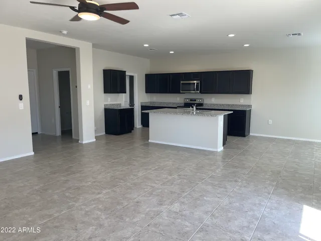 an open kitchen with kitchen island a sink a stove and a refrigerator